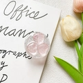 Dettaglio di un supporto per telefono glitterato con tre cuori rosa su carta bianca - Rosa