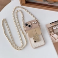 Detalle de funda cruzada con cadena de cuero y cartera con hebilla de lazo de diamante - Caqui / iPhone 15 Plus