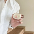 Custodia AirPods Pro bianco panna con fiori 3D e gancio marrone tenuta in mano - AirPods 1ª/2ª generazione / Albicocca (Foglia d'Oro Camelia - Anello Marrone)