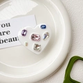 Close-up of heart-shaped phone grip with multi-colored crystals on white ceramic plate - Drip Glue Stand - White Base Colorful Rhinestones - Heart