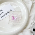 Detailed macro view of a vintage floral frame phone grip with a pink glitter butterfly - Floral Frame Butterfly / Purple
