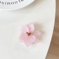 Dettaglio del supporto per telefono a forma di fiore rosa con petali opachi e stami d'oro - Rosa
