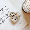 Dettaglio del supporto per telefono a cuore con camelia, perle e strass di lusso - Cuore di Diamanti Completo Camelia Ape / Nero