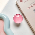 Close-up of pink glossy round retractable phone grip on a minimalist lifestyle setting - White Base Stand / Rose Red