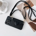 Détail d'une coque iPhone noire avec portefeuille à cœur 3D et crochets dorés - Noir / iPhone 15 Pro Max