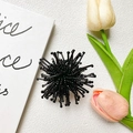 Detailed close-up of a black beaded burst design hair accessory on a minimalist background - Bead Fireworks Style / Black