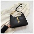 Detail der minimalistischen schwarzen Ledertasche mit goldener Schließe und Kette - Schwarz