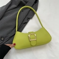 Bolso de hombro verde fluorescente con hebilla dorada sobre fondo de blazer gris - Verde