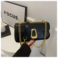 Detailed view of black leather bag with gold geometric lock and metal chain strap - Black