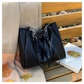 Borsa tote nera con motivo a coccodrillo e tracolla a catena su una panchina autunnale - Nero