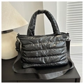 Black quilted puffer handbag with detachable crossbody strap and soft padded design - Black