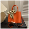 Détail du sac à main orange avec surpiqûres en V et élégant foulard en soie décoratif - Rouge Orangé