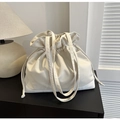 Detail of cream drawstring canvas tote bag with textured ruffles and slender handles - White