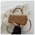 Detail of a brown PU leather crossbody bag with FASHION text and gold hardware - Khaki