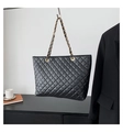 Detail van zwarte gewatteerde shopper met gouden ketting naast een blazer en koffie - Zwart