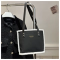 Dettaglio del bordo in lana di agnello a contrasto su borsa tote nera e logo in oro - Nero