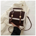Dettaglio borsa a tracolla vintage marrone con bordo in shearling e fibbie in oro - caffè