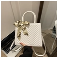 Detailed view of white chevron quilted crossbody bag with decorative silk scarf handle - White