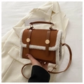 Dettaglio borsa in pelle PU marrone e bianca con bordo in finta lana e fibbie dorate - Cuoio