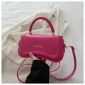 Detail of rose pink handbag featuring golden FASHION lettering and arched top handle - Rose Red