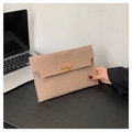 Beige envelope clutch bag with crocodile texture and gold clasp on a minimalist desk - Khaki