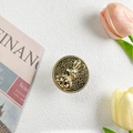 Nahaufnahme der goldenen Hasen-Handyhalterung mit Tulpen und Vintage-Zeitungsdeko - Gold