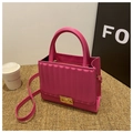 Detail of pink quilted handbag featuring gold hardware and a detachable shoulder strap - Rose Red