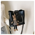 Detail of black PU bucket bag with studded pocket, plush bunny charm and patterned strap - With Rabbit Pendant / Black