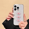 Detalle de funda de iPhone con purpurina y dulces rosas en 3D con lazos naranjas - Morado Purpurina Lazo Corazón / iPhone 15 Pro Max