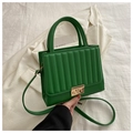 Detailed close-up of emerald green pleated leather handbag with gold buckle and strap - Green