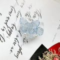 Detailed macro view of heart-shaped phone grip with blue butterfly, rose, and pearls - Transparent Resin Butterfly Flower / Blue