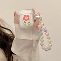 Close-up of clear AirPods case with 3D pink flower and colorful beaded hand strap chain - AirPods 1/2 Gen