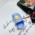 Close-up of blue clog shoe with yellow smiley face charm on a clean white background - Light Blue