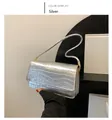 Detailaufnahme einer silbernen Umhängetasche mit Krokoprägung und schmalem Schultergurt - Silber