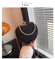 Detail of black sequined heart-shaped clutch with gold chain and rhinestone clasp - Black