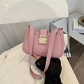 Bolso de hombro de cuero rosa con hebilla dorada mostrado en un ambiente interior - Rosa