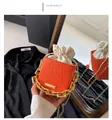 Detail of orange epi-textured bucket bag with golden chain and drawstring closure - Orange