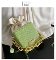 Detail of green wavy texture bucket bag with gold chain and white drawstring pouch - Green