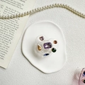 Dettaglio del supporto per telefono a cuore con gemme colorate su vassoio in ceramica - Trasparente