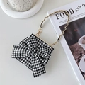 Detalle de mini bolso de pata de gallo con lazo grande y cadena dorada sobre fondo decorativo - Estilo de Lazo de Pata de Gallo / OPPO Find N2 Flip