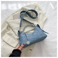 Detail van blauwe denim halve maan tas met zilveren ketting op witte blazer - Denim Blauw