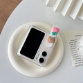 Detail of clear folding phone case with tulip strap and 3D bear charm on ceramic plate - Tulip Bear (Findn2Flip)