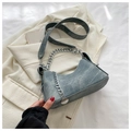 Detail van vintage denim halve maantas met zilveren ketting op blazerstof textuur - Vintage Blauw