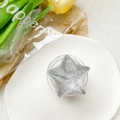 Dettaglio di gel glitterato argento a forma di stella su un vassoio decorativo bianco - Stella Glitterata Argento