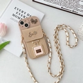 Detalle de funda de iPhone acolchada beige con colgante de perfume y cadena metálica - Caqui / iPhone 15 Plus