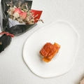 Close-up of a realistic salmon food-shaped collapsible phone grip on a white ceramic plate - 3D Fried Ribs