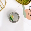 Close-up of luxury round phone grip mirror with shimmering diamond-set silver frame - Small Round - Silver
