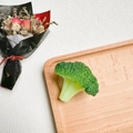 Macro view of realistic broccoli-shaped phone grip on a minimalist wooden tray - 3D Broccoli