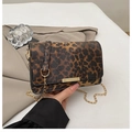 Detail der Leopard-Umhängetasche mit goldener Kette und Metallverschluss auf beigem Blazer - Leopard Dunkelbraun