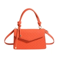 Orange woven textured shoulder bag with thick round handle and detachable strap on white background - Orange